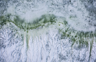 Stains on the sand background. Ripple effect texture. White ground and water with oil in the lake.