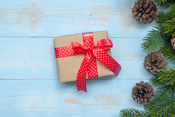 Christmas decoration, gift box and pine tree branches on wooden background, preparation for holiday concept, Happy New Year and Xmas Holidays. Top view and Copy Space for text