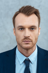 close up portrait of handsome young businessman looking at camera in office