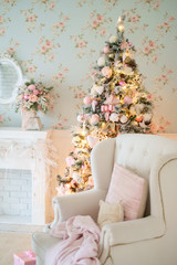 Decorated Christmas tree in classic interior with fireplace and armchair.