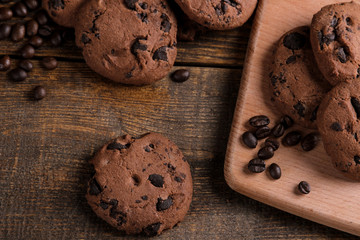 Tasty sweet cookies with chocolate and grains of coffee on a brown wooden table. view from above