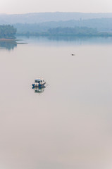 Obraz na płótnie Canvas Flying bird, motorboat on a scenic waterscape background in Goa