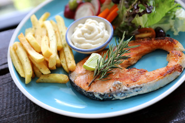 Roasted salmon steak , baked salmon with salad fresh vegetable pm wooden table