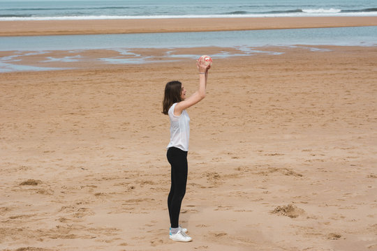 Teenager playing with ball on beachs