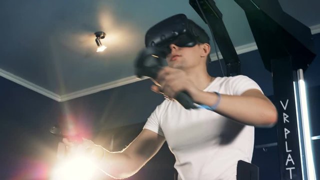 Virtual reality headset playing game 360. Virtual reality system is being used by a man who's moving his hands