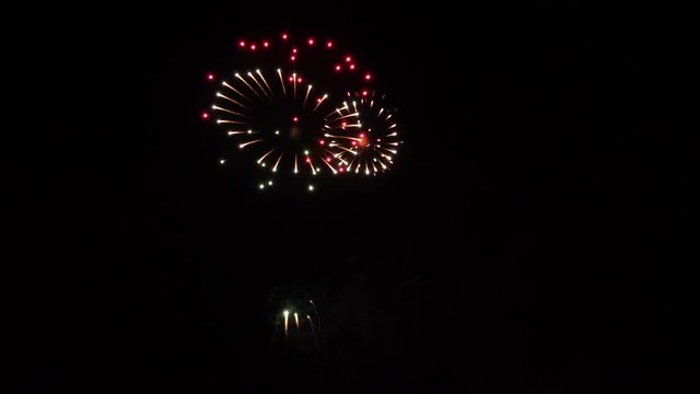 Slow motion fireworks show with red star ball rings