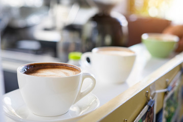 Hot art Latte Coffee in a cup on wooden table and Coffee shop blur background with bokeh image