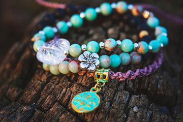 Three bracelets with gemstone beads on wooden background - obrazy, fototapety, plakaty