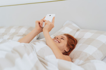 Happy young woman reading a message on her mobile