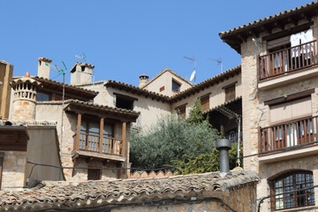 Typical rural stone made house with wooden windows, wrought iron or wooden railings and climbing ivy in Alquezar, Spain