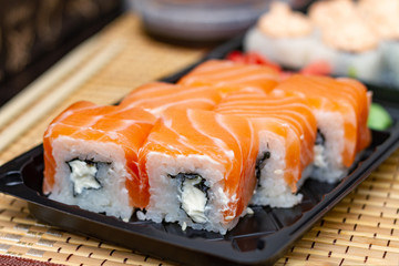 Sushi rolls on a plastic plate. Delivery of Asian food home.