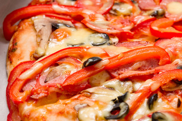 Pizza with salami, cheese and  red pepper. Selective focus. Close up.