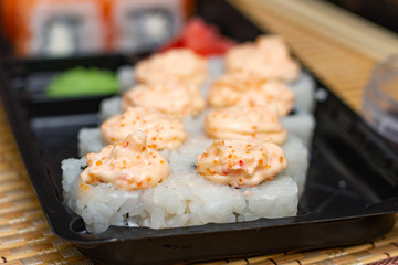 Sushi rolls on a plastic plate. Delivery of Asian food home.