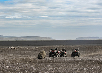 Four quad bikes in Solheimasandur plane wreck place: black sand desert landscape in South Iceland, Europe © nomadkate
