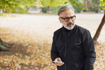 Senior man walking through an autumn park