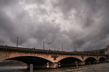 Fototapeta premium Bridge over the river in Paris and dramatic sky. 