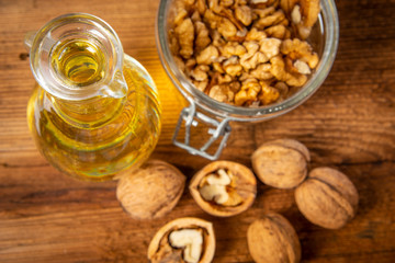 fresh walnuts and oil on an old wooden table