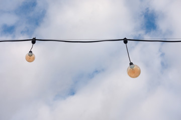 Fototapeta na wymiar Orange light bulbs against the sky