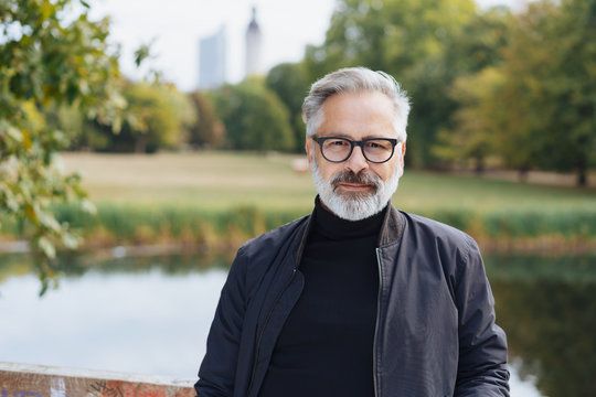 Trendy senior bearded man in a city park