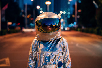 Spaceman on a street in the city at night