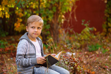 boy sitting in the woods on a log