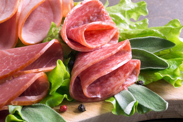 slices of French cheese-dried salami with spices on wooden background