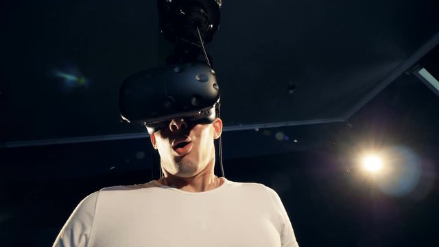 A man in virtual reality goggles is getting surprised