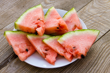 Sliced watermelon in a plate on wooden table