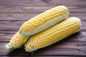 Fresh corn on a brown wooden background