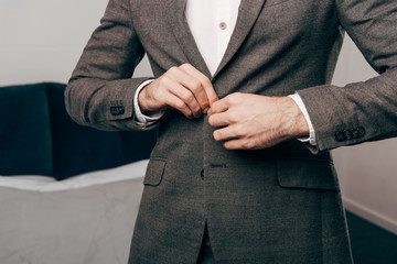 cropped image of businessman buttoning up jacket