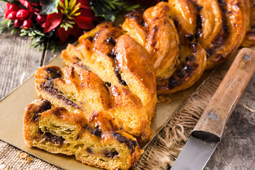Homemade braid stuffed with chocolate and cut into pieces on wooden table. Close up	