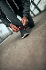 Runner tying his shoelaces after run.