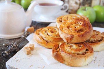 Sweet buns with apple and cinnamon, green apples and cup of tea