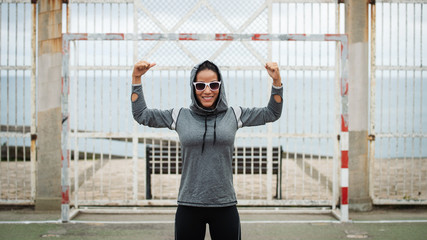 Strong fitness young woman flexing arms biceps. Workout success and healthy lifestyle concept.