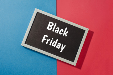 Black Friday - text on chalkboard on blue and red background.
