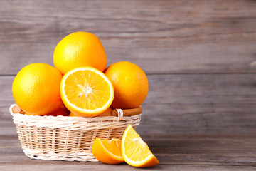 Orange fruit in basket on a grey background
