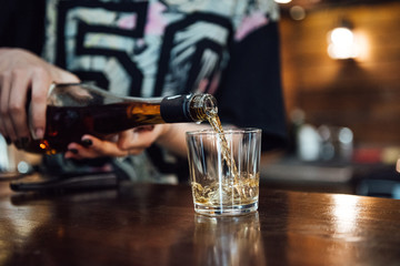 whiskey is poured into a glass from a bottle