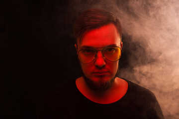 Vape man. Portrait of a bearded man on a black background close-up.