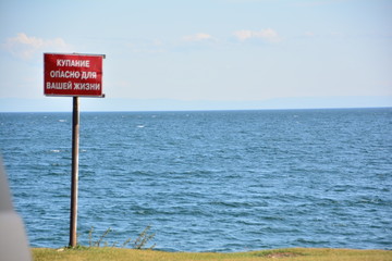 Table warning about the danger of swimming in lake Baikal near the village of Bolshoe Goloustnoe, August 2018