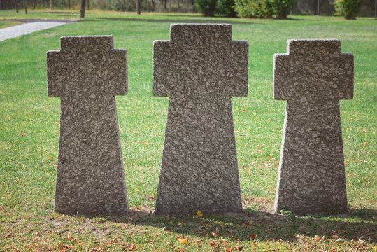 close up image of memorial stone crosses placed in row at graveyard