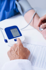 doctor measuring the blood pressure of a senior