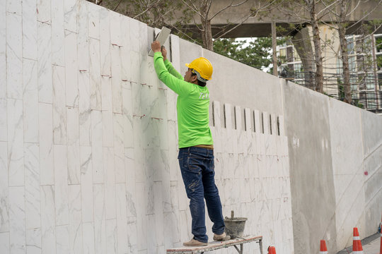 mason worker during installed white gray marble on the wall © somchaikhun