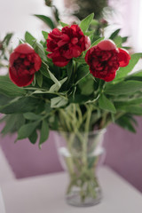 bouquet of red peonies in a vase on the white chair, wedding decoration