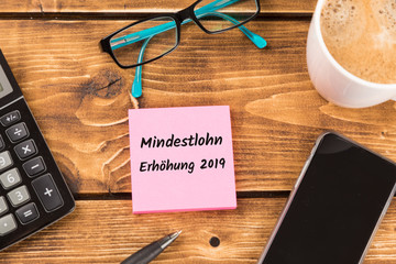 desk with german text mindestlohn erh&ouml;hung 2019, in english minimum wage increase 2019