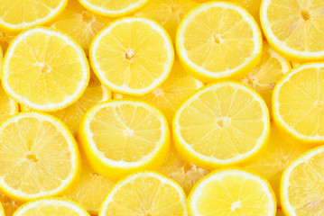 A slices of fresh juicy yellow lemons.  Texture background, pattern.