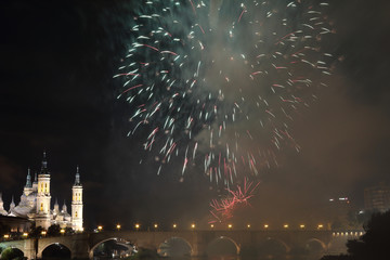 The fireworks during the 2018 Pilar festival next to the Pilar Cathedral and the Stone Bridge over...