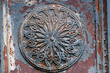 Antique forged element in the shape of a circle with peeled paint