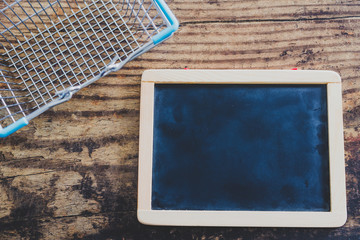 blackboard next to empty shopping cart with copyspace