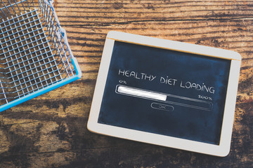 blackboard next to empty shopping cart with Healthy Diet Loading text and progress bar