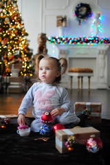 Ребенок ждет чуда в Новый год. С новым годом! Счастливого Рождества! Новогодняя елка с рождественскими игрушками. Девочка  с подарками.
